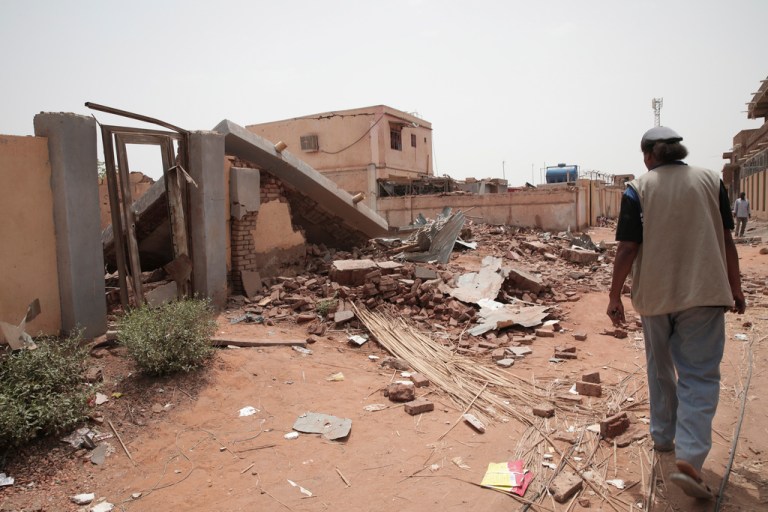 A man walks by a house hit in recent fighting in Khartoum, Sudan, Tuesday, April 25, 2023. Sudan's warring generals have pledged to observe a new three-day truce that was brokered by the United States and Saudi Arabia to try to pull Africa's third-largest nation from the abyss. 