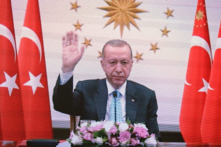Turkish President Recep Tayyip Erdogan is seen on a TV screen as he attends a videoconference ceremony with Russian President Vladimir Putin.