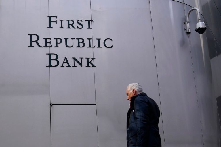 A pedestrian walks past a sign at a First Republic Bank in San Francisco on April 26, 2023. Regulators continued their search for a solution to First Republic Bankâs woes over the weekend before stock markets were set to open Monday, May 1. 