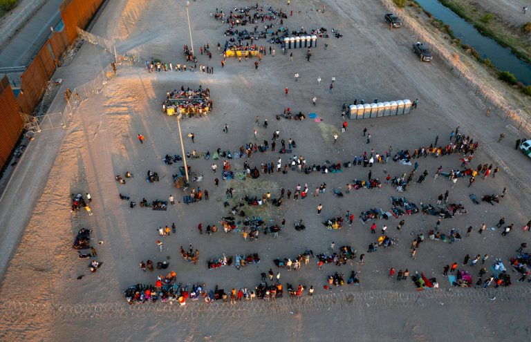 Migrants wait outside a gate in the border fence to enter into El Paso, Texas, to be processed by the Border Patrol, Thursday, May 11, 2023. (AP Photo/Andres Leighton)