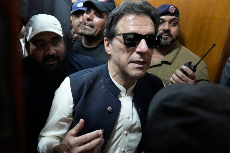Former Pakistani Prime Minister Imran Khan, center, leaves court after an appearance in Lahore, Pakistan, Friday, May 19, 2023. Khan dialed down his campaign of defiance on Friday, saying he would allow a police search of his home over allegations that he was harboring suspects wanted in recent violence during anti-government protests by his supporters.  