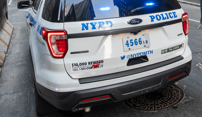 A police car sits outside the Roosevelt Hotel after the arrival of asylum seekers on Friday, May 19, 2023, in New York.