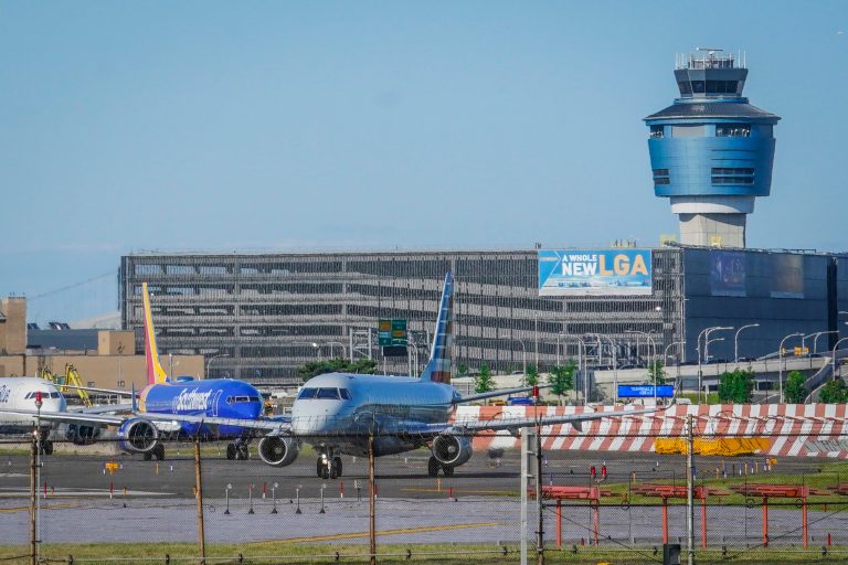 FILE - LaGuardia Airport's air traffic control tower, right, is shown as planes line up for takeoff, May 25, 2023, in New York. (AP Photo/Bebeto Matthews, File)