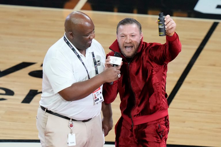 Former UFC champion Conor McGregor promotes a pain-relief spray during a break in Game 4 of the basketball NBA Finals between the Miami Heat and the Denver Nuggets, Friday, June 9, 2023, in Miami. 