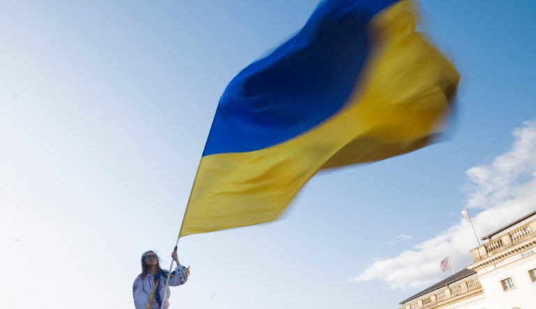 A woman waves a Ukrainian flag as she attends a protest against the war in Ukraine in Berlin, Germany, Tuesday, June 13, 2023.