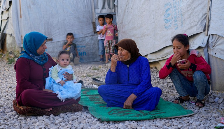 A Syrian family sits in front of their tent at a refugee camp in the town of Bar Elias, in Lebanon's Bekaa Valley, Tuesday, June 13, 2023. 
