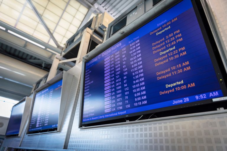 A screen displays departure times and delayed flight information Wednesday, June 28, 2023, for Terminal C in Newark International Airport.