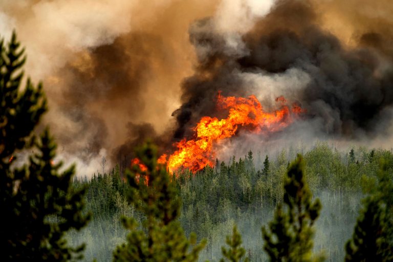 Flames from the Donnie Creek wildfire burn along a ridge top north of Fort St. John, British Columbia, Canada.