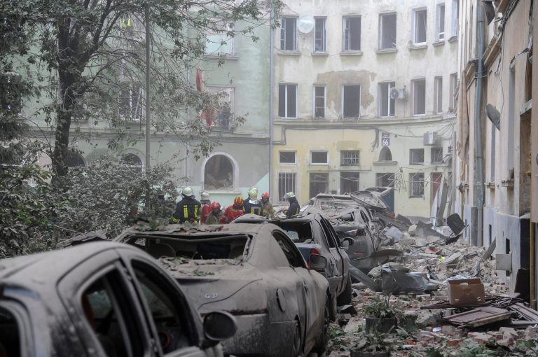 Emergency service workers gather outside damaged buildings as the search for victims continues following a Russian missile attack in Lviv, Ukraine, Thursday, July 6, 2023. 