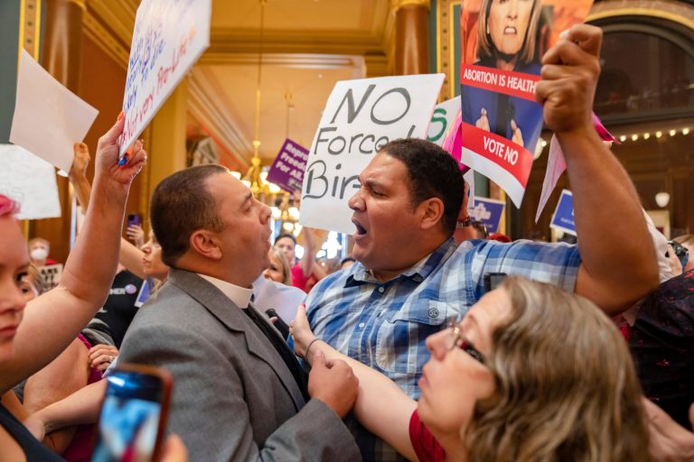 Pastor Michael Shover of Christ the Redeemer Church in Pella, left, argues with Ryan Maher, of Des Moines, as protesters clashed in the Iowa State Capitol rotunda while the Iowa Legislature convenes for special session to pass a six-week 