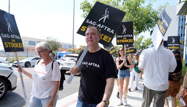 Rep. Adam Schiff, D-Calif., center, carries a sign on a picket line outside Netflix studios in Los Angeles on Monday, July 17, 2023. (AP Photo/Chris Pizzello)