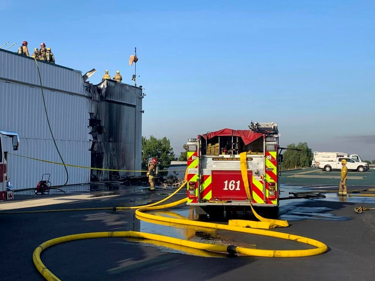 This photo provided by the San Bernardino County Fire Department shows personnel responding to a small plane that crashed into a hanger at Cable Airport.