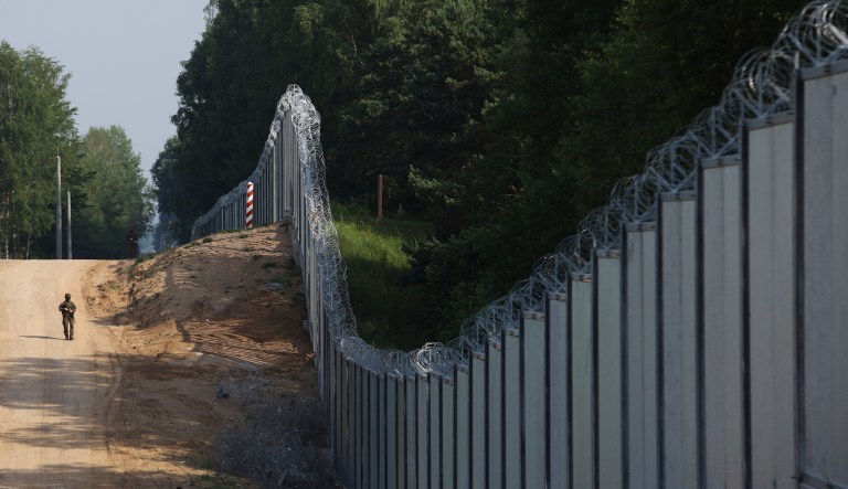 A Polish border guard patrols the area of a built metal wall on the border between Poland and Belarus, near Kuznice, Poland, on June 30, 2022. NATO allies located along the allianceâs eastern front are growing increasingly worried about the presence of Russia-linked Wagner group mercenaries in Belarus.