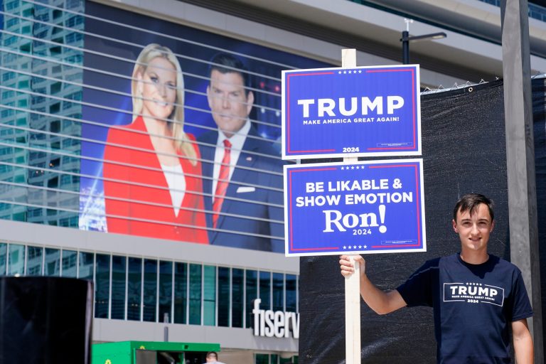 A supporter of former President Donald Trump stands near the Fiserv Forum as set up continues for the upcoming Republican presidential debate Tuesday, Aug. 22, 2023, in Milwaukee. (AP Photo/Morry Gash)