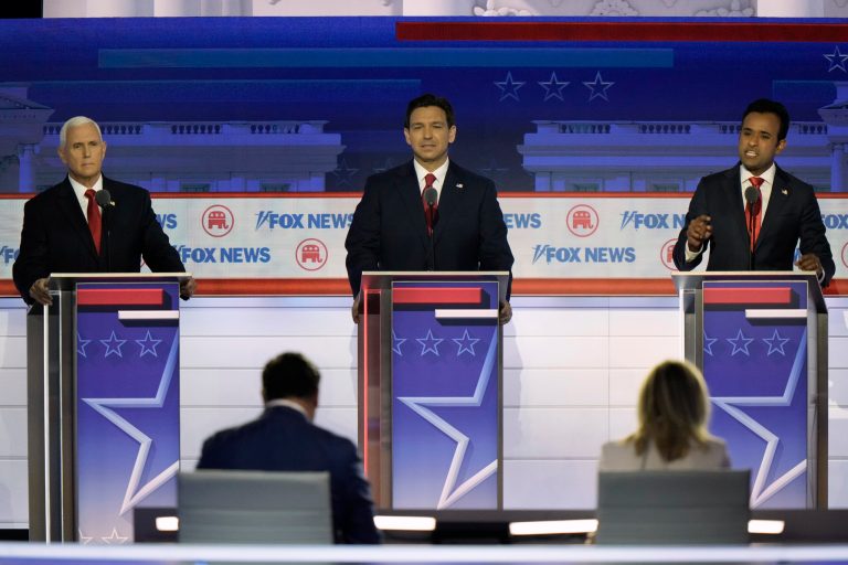 Businessman Vivek Ramaswamy speaks as former Vice President Mike Pence and Gov. Ron DeSantis (R-FL) listen during a Republican presidential primary debate hosted by Fox News on Wednesday, Aug. 23, 2023, in Milwaukee.