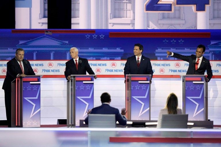 Vivek Ramaswamy, Ron DeSantis, and Mike Pence look toward Chris Christie during a Republican presidential primary debate in Milwaukee.