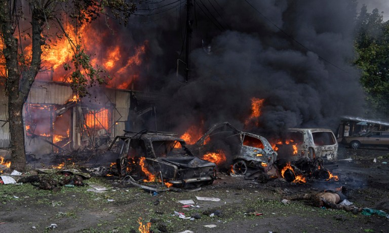 A dead body lies on the ground in front of a burning market after a Russian shelling attack in the city center of Kostiantynivka, Ukraine, Wednesday, Sept. 6, 2023.  (AP Photo/Evgeniy Maloletka)