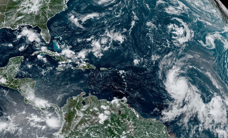 This Wednesday, Sept. 6, 2023, satellite image provided by the National Oceanic and Atmospheric Administration shows Hurricane Lee, right, off in the central tropical Atlantic Ocean. 