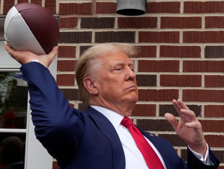 Former President Donald Trump throws a football to the crowd during a visit to the Alpha Gamma Rho fraternity at Iowa State University before the Iowa-Iowa State game Saturday, Sept. 9, 2023, in Ames, Iowa.