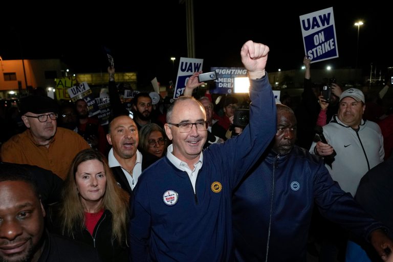 United Auto Workers President Shawn Fain walks with union members striking at Ford's Michigan Assembly Plant in Wayne, Michigan, early Friday, Sept. 15, 2023. 
