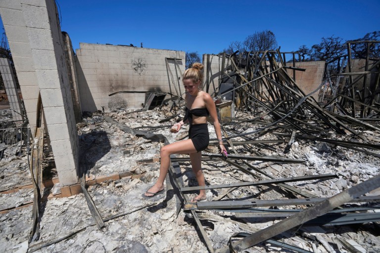 Sydney Carney walks through her home, which was destroyed by a wildfire on Aug. 11, 2023, in Lahaina, Hawaii. Lahaina residents are grappling with a range of feelings as Maui authorities plan to begin allowing them back into what has become known as the 