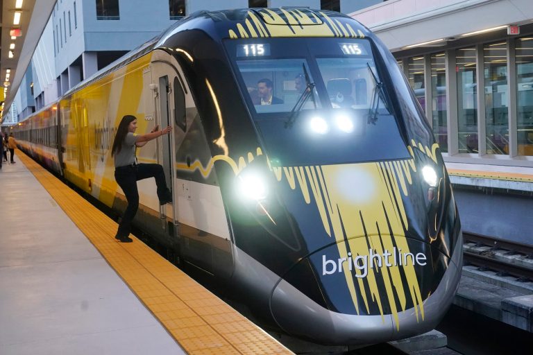 Brightline conductor Megan Olshefki boards the train on its inaugural route from Miami to Orlando Friday, Sept. 22, 2023. Brightline, is the first private intercity passenger service to begin U.S. operations in a century. (AP Photo/Marta Lavandier).