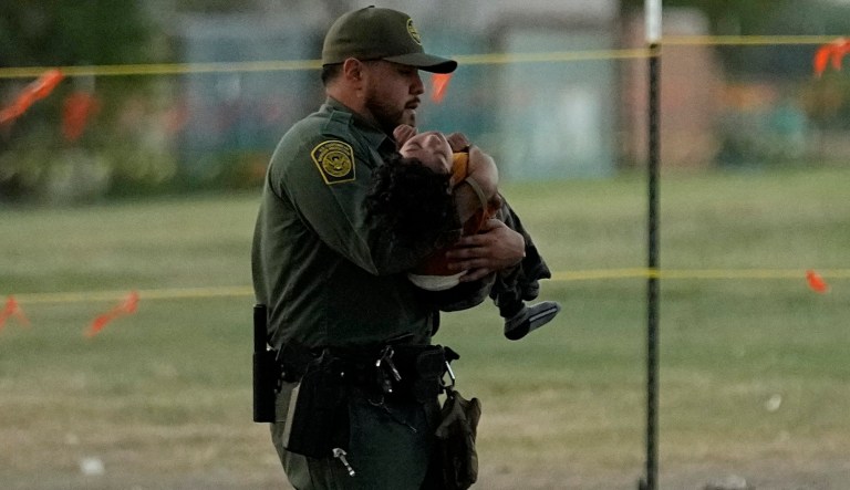 A U.S. Border Patrol agent helps a small migrant child that crossed the Rio Grande from Mexico to the U.S. with a group, Friday, Sept. 22, 2023, in Eagle Pass, Texas.