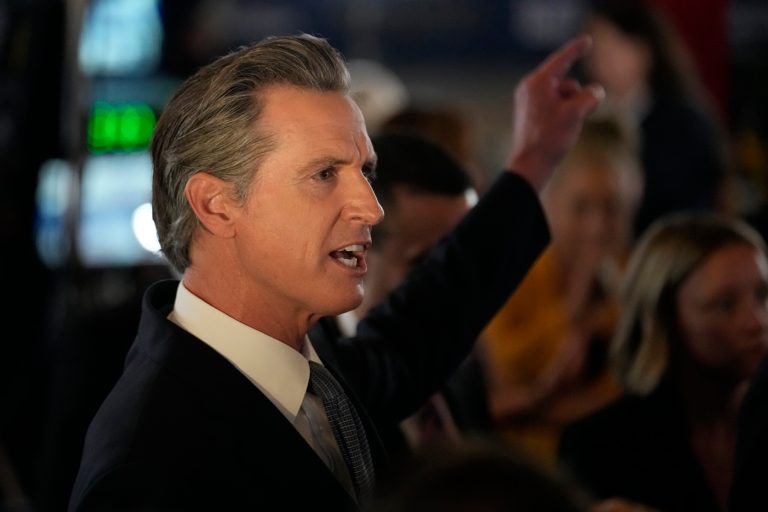California Gov. Gavin Newsom fields questions in the spin room before a Republican presidential primary debate Sept. 27, 2023.