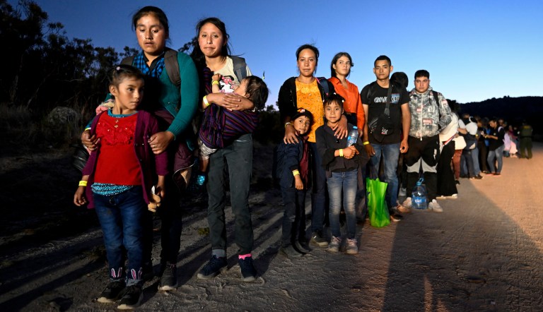 Asylum-seekers from Peru wait to be processed by U.S. Border Patrol agents after crossing the nearby border with Mexico, Tuesday, Sept. 26, 2023, near Jacumba Hot Springs, California.
