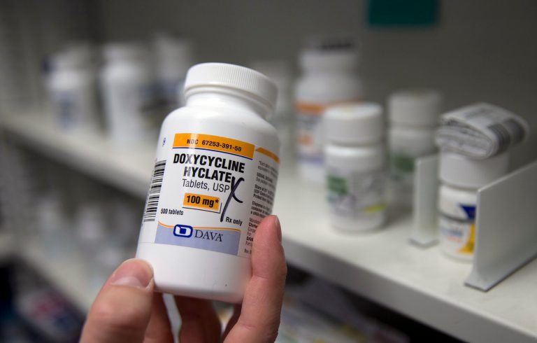 FILE - A pharmacist holds a bottle of the antibiotic doxycycline hyclate in Sacramento, Calif., July 8, 2016. (AP Photo/Rich Pedroncelli, File)