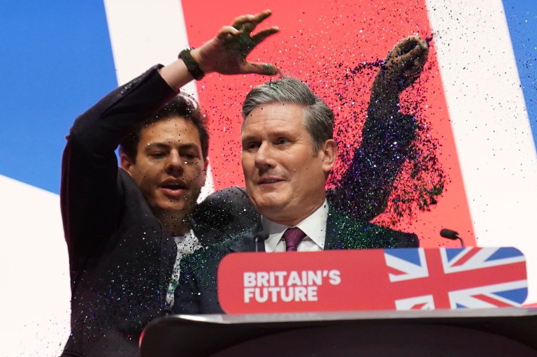 A protester throws glitter and disrupts Labour leader Sir Keir Starmer making his keynote speech during the Labour Party conference in Liverpool, England, Tuesday, Oct. 10, 2023.
