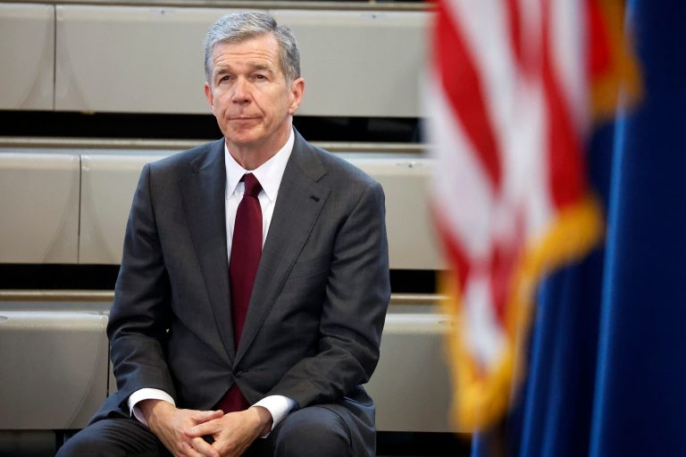 Gov. Roy Cooper (D-NC) listens as Democratic gubernatorial candidate Josh Stein speaks at a rally at Shaw University in Raleigh, North Carolina, Tuesday, Oct. 10, 2023.