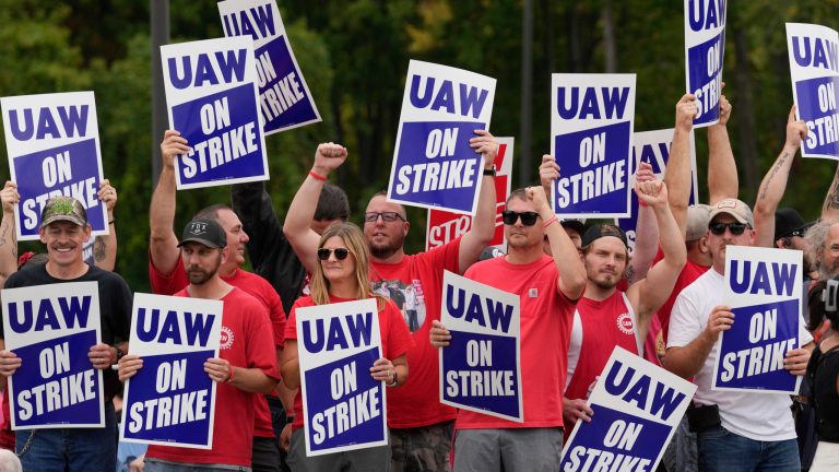 United Auto Workers members hold picket signs near a General Motors Assembly Plant in Delta Township, Michigan, on Sept. 29, 2023.