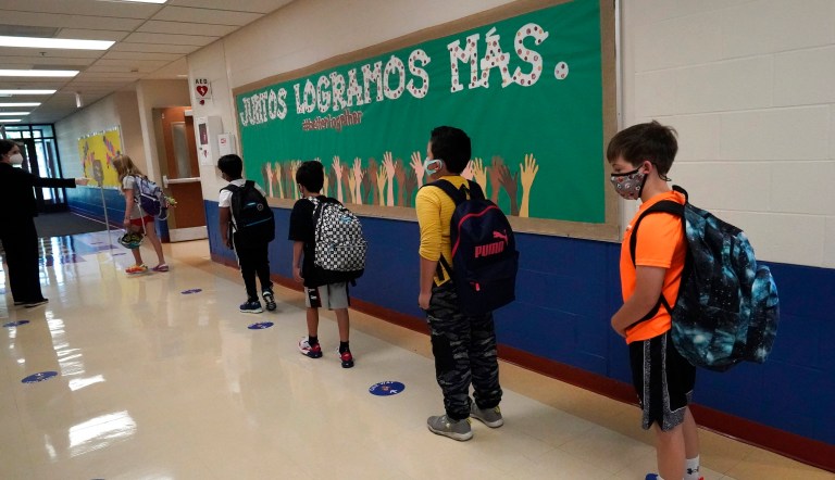 Students keep social distance as they walk to their classroom, Sept. 3, 2020, in Highwood, Illinois. The shortage of teachers in Illinois has slowed and even improved, but gaps in critical areas such as special education remain, and racial diversity among school leaders lags far behind that of the state's pupils, according to a study released Thursday, Oct. 12, 2023. 