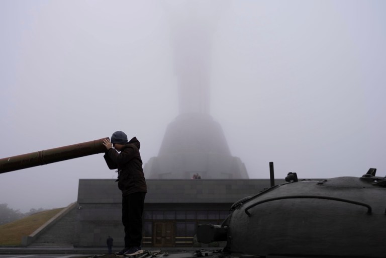 A boy plays on a tank installed as a monument in Kyiv, Ukraine, in front of the Motherland monument, just reopened for public viewing on Saturday, Oct. 21, 2023. 