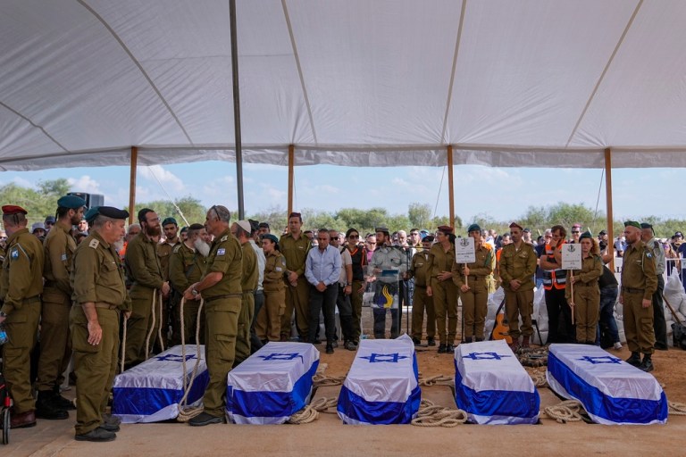 FILE - Mourners gather around the five coffins of the Kotz family during their funeral in Gan Yavne, Israel, Tuesday, Oct. 17, 2023. 