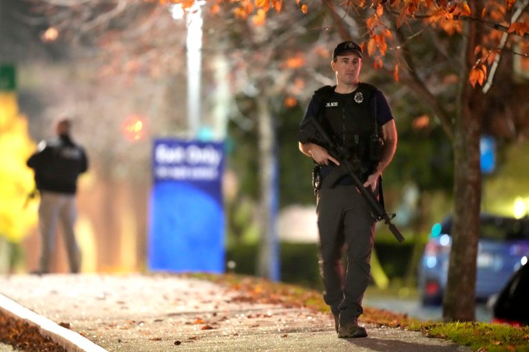 Law enforcement officers carry rifles outside Central Maine Medical Center during an active shooter situation in Lewiston, Maine.
