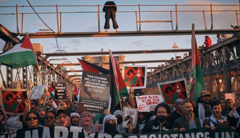 Palestinian supporters shout slogans as they cross the Brooklyn Bridge during a demonstration demanding a cease-fire on Saturday, Oct. 28, 2023, in New York.
