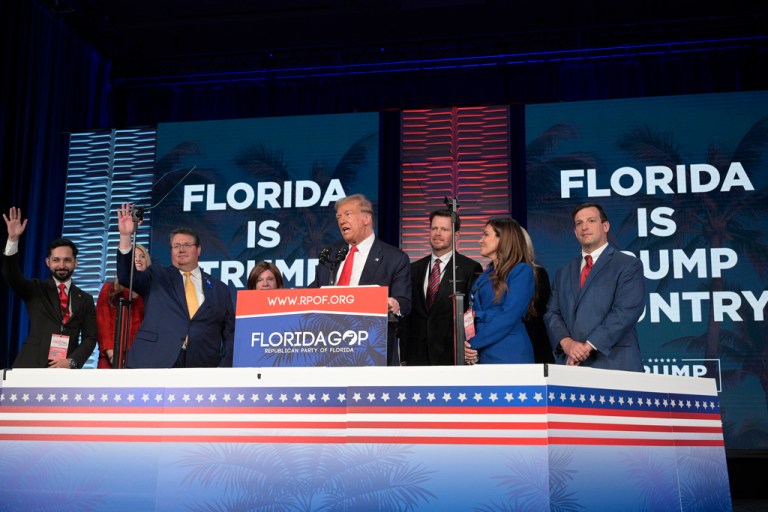 Former President Donald Trump, center, is surrounded on stage by supporters at the Republican Party of Florida Freedom Summit, Saturday, Nov. 4, 2023, in Kissimmee, Fla. 
