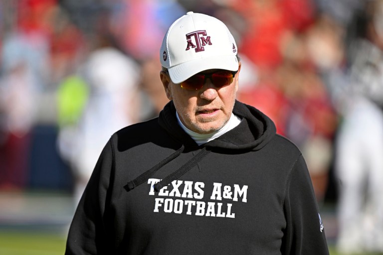 Jimbo Fisher walks on the field during warmups before a game against Mississippi in Oxford, Mississippi, Saturday, Nov. 4, 2023.