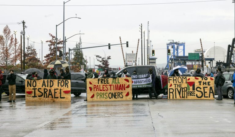 Cars, signs, and hundreds of pro-Palestinian protesters gather at the Port of Tacoma at Terminal 7 to block the entrance at where they believe to be a military ship bound for Israel, Monday, Nov. 6, 2023. 