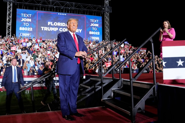 Former President Donald Trump arrives to speak at a campaign rally in Hialeah, Florida, Wednesday, Nov. 8, 2023, as Gov. Sarah Huckabee Sanders (R-AR) stands right.
