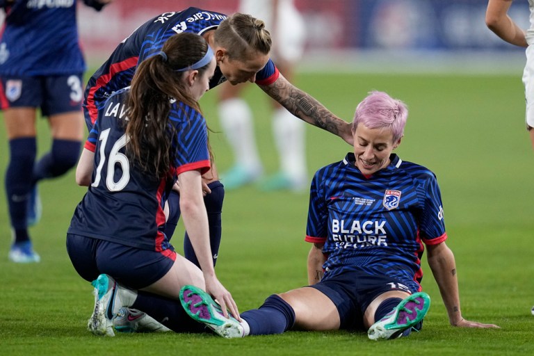 OL Reign forward Megan Rapinoe, right, stays down after an injury as teammates midfielder Rose Lavelle (16) and midfielder Jess Fishlock, center, check on her during the first half of the NWSL Championship soccer game against NJ/NY Gotham, Saturday, Nov. 11, 2023, in San Diego.