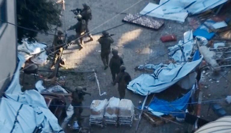 In this image taken from a video released by the Israeli Defense Forces on Tuesday, Nov. 15, 2023, Israeli soldiers walk in the area of Shifa Hospital in Gaza City.