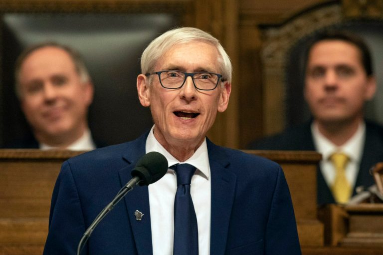 Gov. Tony Evers (D-WI), with Assembly Speaker Robin Vos, left, and Senate President Roger Roth behind him, addresses a joint session of the legislature in the Assembly chambers during his State of the State speech on Tuesday, Jan. 22, 2019, at the state Capitol in Madison, Wisconsin.