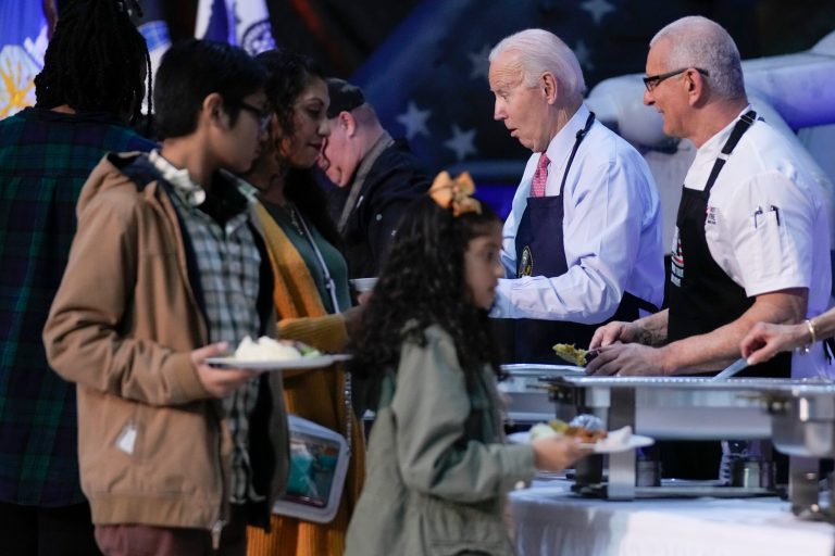 President Joe Biden jokes with children in line as he and chef Robert Irvine help serve a 
