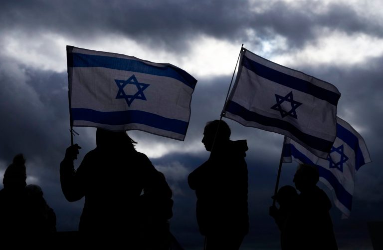 Demonstrators hold flags of Israel during a rally and march for Israel on Sunday, Nov. 19, 2023, in the Seattle suburb of Kirkland, Washington.