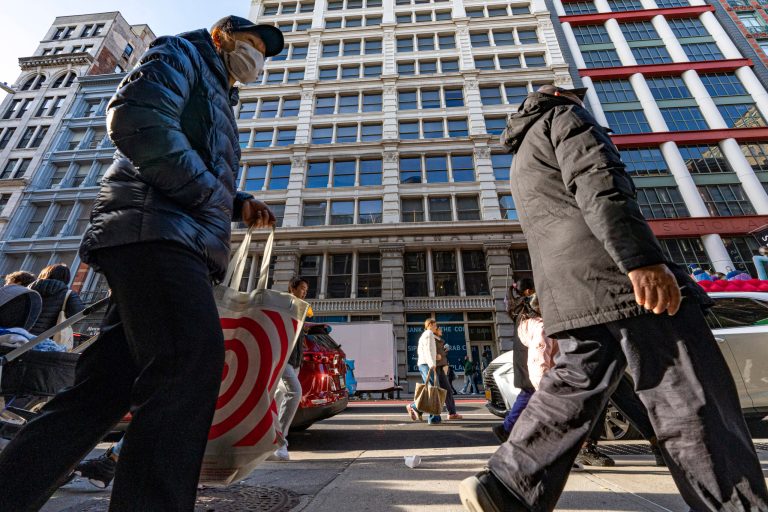 Shoppers walk down a sidewalk on Black Friday in New York, Friday, Nov. 24, 2023.