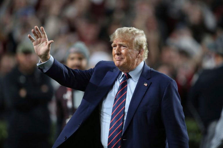 Republican presidential candidate and former President Donald Trump waves during halftime of an NCAA college football game between South Carolina and Clemson, Saturday, Nov. 25, 2023, in Columbia, South Carolina.