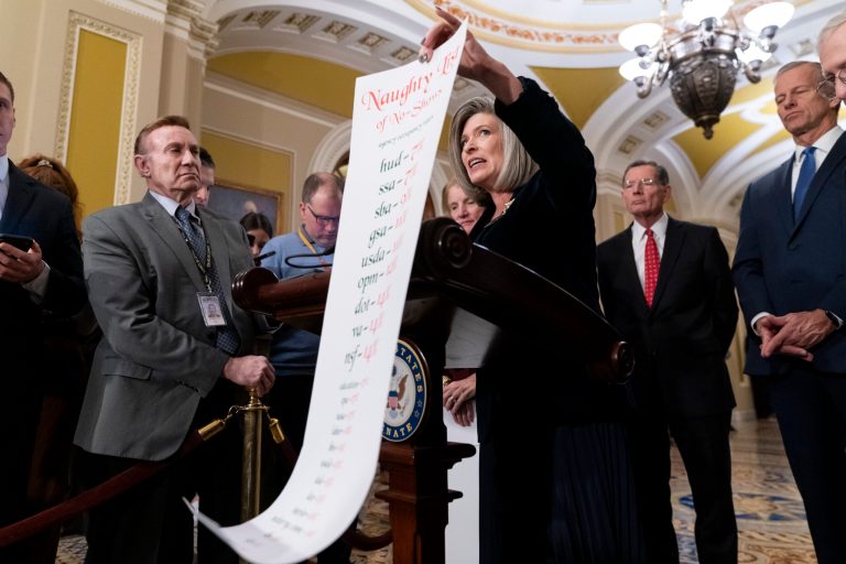 Sen. Joni Ernst (R-IA) holds up a 